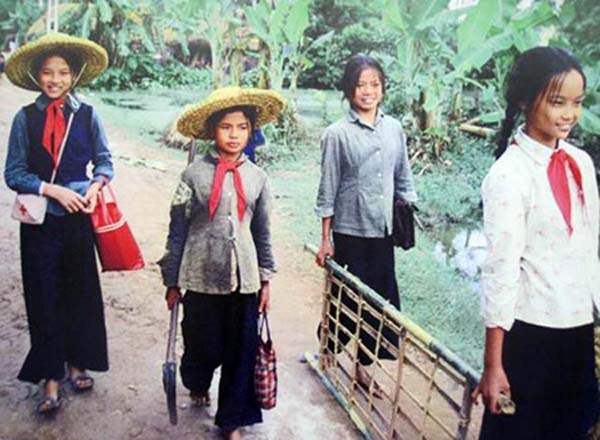 Thời chiến, học trò đến trường, trên đầu là bom rơi đạn nổ. Ngoài sách vở thì mũ rơm, túi tre và cáng cứu thương là những vật dụng không thể thiếu trong hành trang đi học.