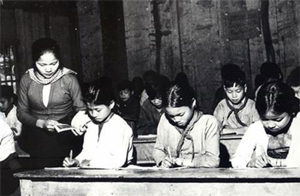 Cô giáo sát sao việc học của học sinh.