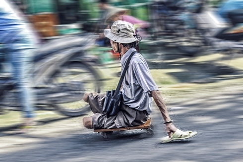 Đôi tay từ lâu đã thay thế đôi chân cho người bán vé số rong đuổi khắp các khu chợ để mưu sinh.