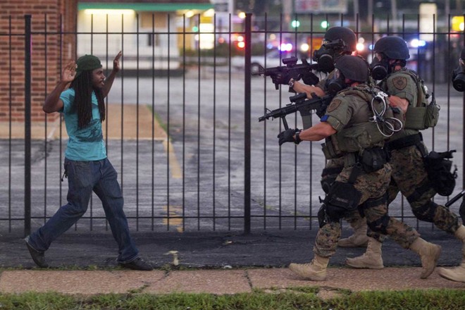 Người biểu tình đối đầu với cảnh sát vũ trang trong cuộc bạo động ở Ferguson, Missouri, Mỹ sau vụ việc cảnh sát da trắng Darren Wilson bắn chết thanh niên da màu không mang vũ khí Michael Brown hôm 9/8.