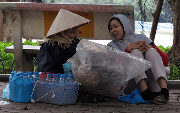 Cụ già bán nước ven hồ Gươm, nép mình sau ghế đá tránh gió lạnh.