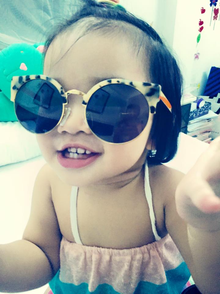 Con gái siêu mẫu Xuân Lan tỏ ra vô cùng thích thú khi được mẹ cho đeo kính râm.