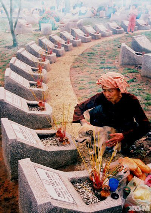 Bức ảnh 'Tháng 7 thăm con' với lời tựa: 'Tháng 7, mẹ đón xe đò lên thành phố, vào nghĩa trang liệt sĩ thăm con trai. Những bánh, trái, thuốc lá... ngày nào con vẫn thích mẹ mang cho con cả...'