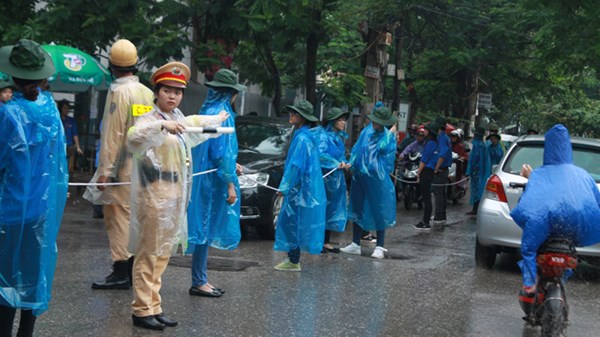 Nữ CSGT đội mưa phân luồng giao thông trong kỳ thi Đại học Cao đẳng 2014.