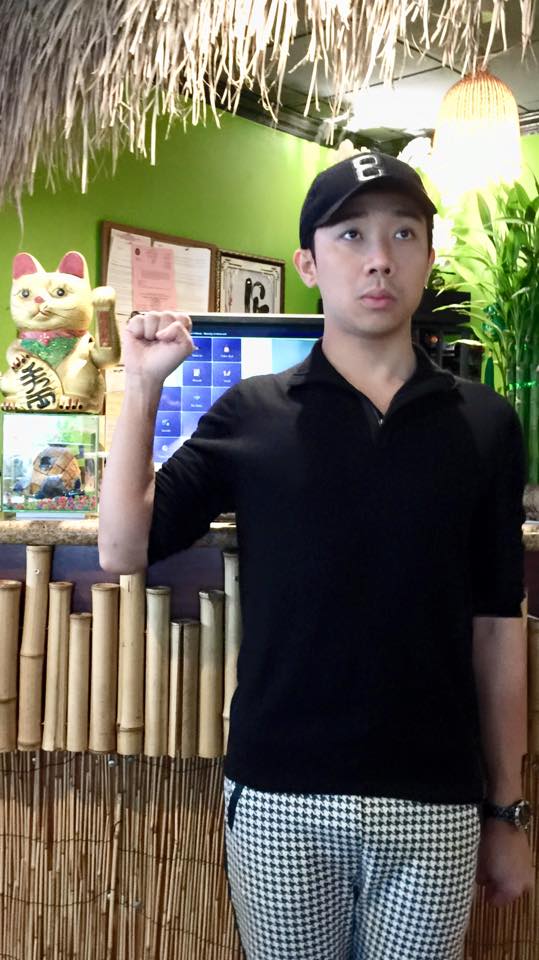 Trấn Thành hài hước đứng và vãy tay the chú mèo đằng sau mỗi lần có khách vào quán ăn.