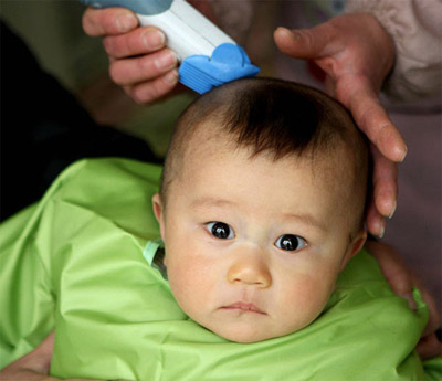 Em ngồi ngoan cho cô chú cắt tóc.
