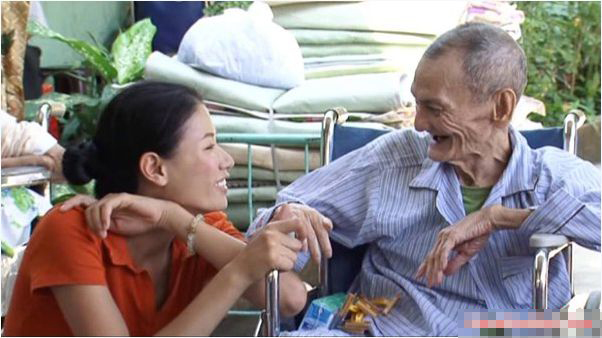 Cô trò chuyện với một cụ già đang điều trị bệnh.