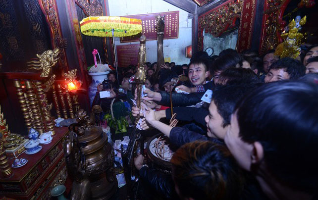 Bên trong cung, dòng người chen lấn, xô đẩy để được xoa tiền vào thanh kiếm lấy may.