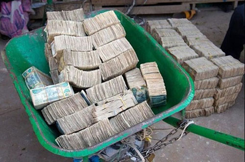 Tiền được chở bằng xe cút kít.
