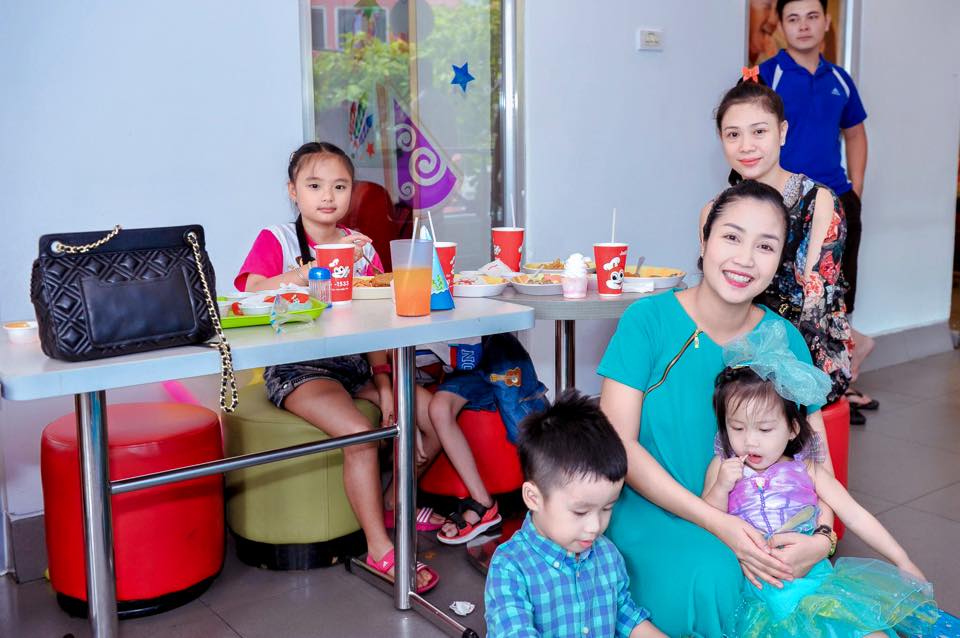 Bé Cola ngồi yên trong vòng tay của mẹ.