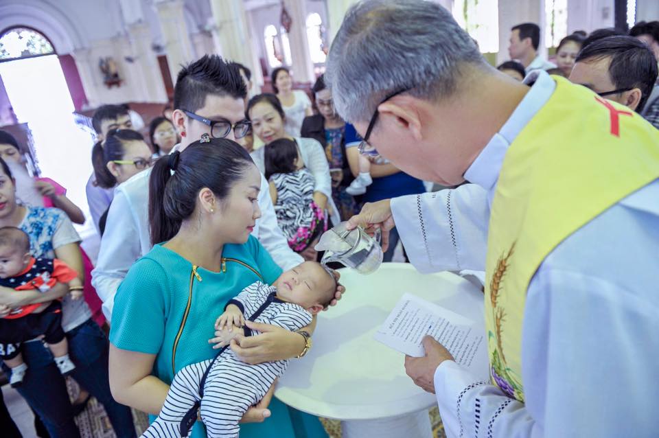 Bé Vinh Hy ngoan ngoãn tại buổi lễ rửa tội.