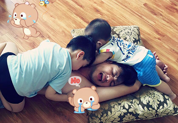 Diễn viên Đan Lê chú thích về bức ảnh hai con trai đè lên người bố: 'Giờ chơi đã đến rồi, hehe'.
