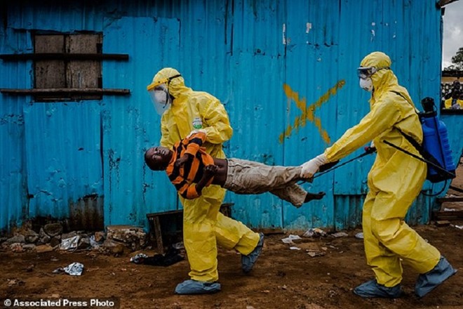 Nhân viên y tế khiêng cậu bé Dorbor, 8 tuổi, đến trung tâm điều trị Ebola ở Monrovia, thủ đô của Liberia, vì nghi cậu nhiễm virus. Tác phẩm của Daniel Berehulak, phóng viên của báo New York Times.