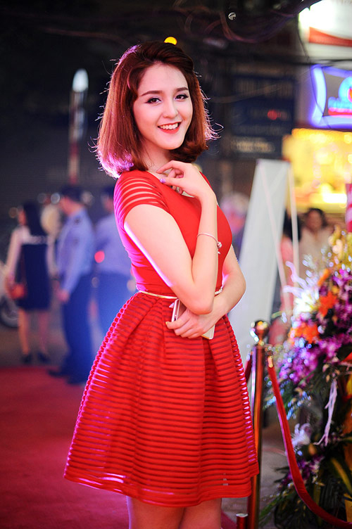 Á hậu Hoàng Anh rạng rỡ, trẻ trung khi diện bộ đầm dáng xòe màu đỏ nhấn nhá những đường kẻ xuyên thấu sinh động.