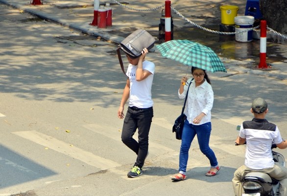 Hai Mừng SHBET phiên bản mới 2025 Đại học công đoàn trên đường Tây Sơn phải dùng ô, cặp sách để che nắng trên đường đến trường.