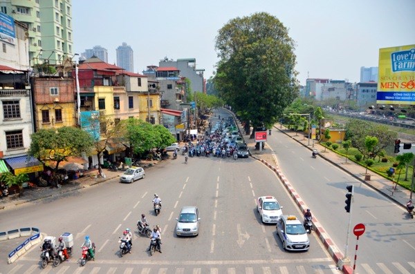 Những bóng cây trên đường trở thành nơi trú chân cho nhiều người đi đường trong lúc chờ đèn đỏ.