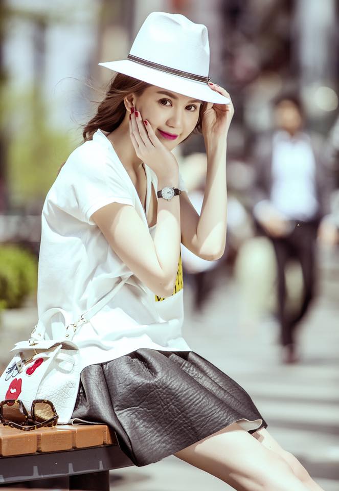 Ngọc Trinh khoe style dịu dàng với áo thun rộng, chân váy da xòe và mũ rộng vành.