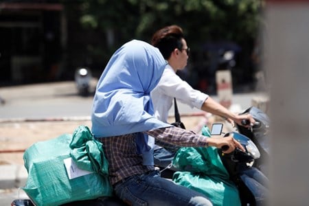 Một nam thanh niên cũng phải lấy áo che nắng.