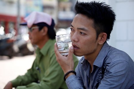 Cầm một cốc nước đá áp vào mặt cho mát.