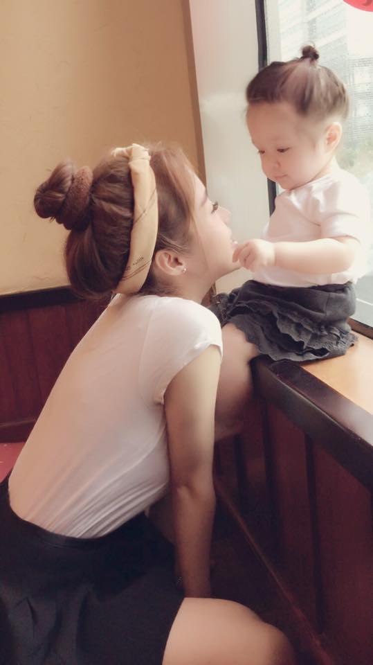 Cadie Mộc Trà trông như bản sao của mẹ khi cả 2 cùng mặc đồ đen trắng và búi tóc cao nô đùa bên khung cửa.