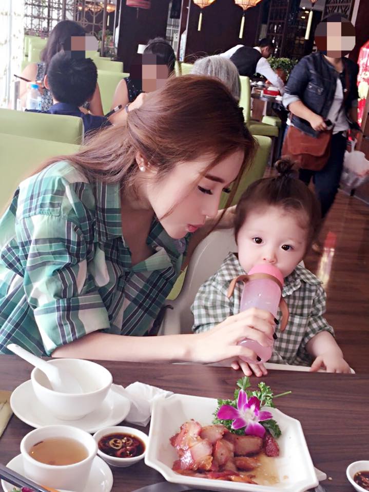 Elly trần nhẹ nhàng cho con gái uống nước.