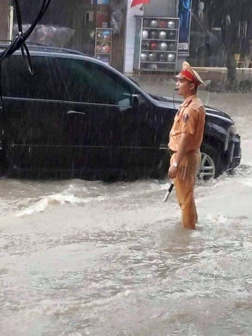 CSGT phân luồng giao thông trong trời mưa nặng hạt.
