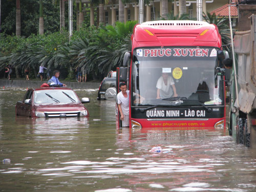 Các phương tiện di chuyển vất vả giữa dong nước lũ.