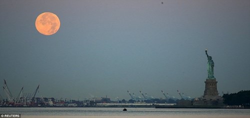 Hình ảnh trăng dần tròn xuất hiện cùng tượng Nữ thần Tự do ở đảo Staten, bang New York, Mỹ hôm 30/7 (giờ địa phương).