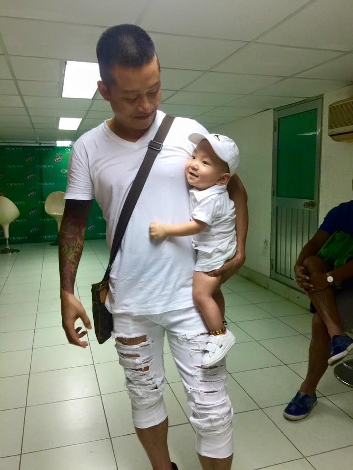 Tuấn Hưng bế 'cắp nách' con trai Su Hào. Gương mặt bé siêu đáng yêu.