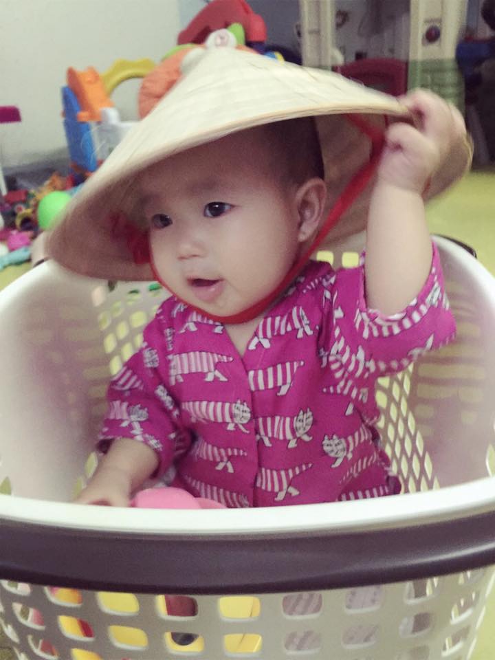 Sunny được anh chị cho ngồi vào giỏ nhựa khiến bé vô cùng thích thú.