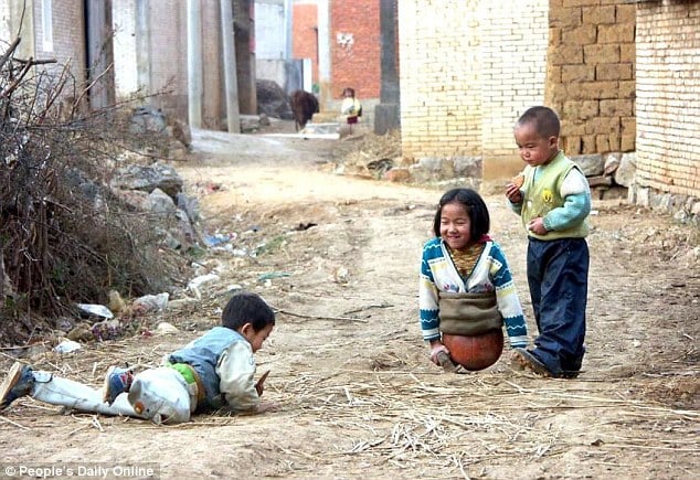 Cô bé chơi đùa với bạn bè trên một quả bóng rổ. Ảnh: Nhân dân Nhật báo.
