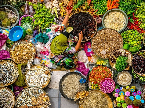 17. Kota Bharu, Malaysia: Những mẹt nông sản và cá tươi đầy màu sắc vây quanh một người phụ nữ đang bán hàng ở chợ Siti Khadijah, Kota Bharu, Malaysia. Ảnh: Duratul Ain D.