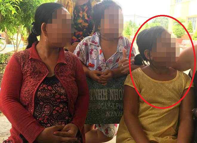 Bé Tr. (áo vàng), người bị cha ruột nhiều lần thực hiện hành vi đồi bại trong ngày đến cơ quan chức năng làm việc. (Ảnh: Người đưa tin)