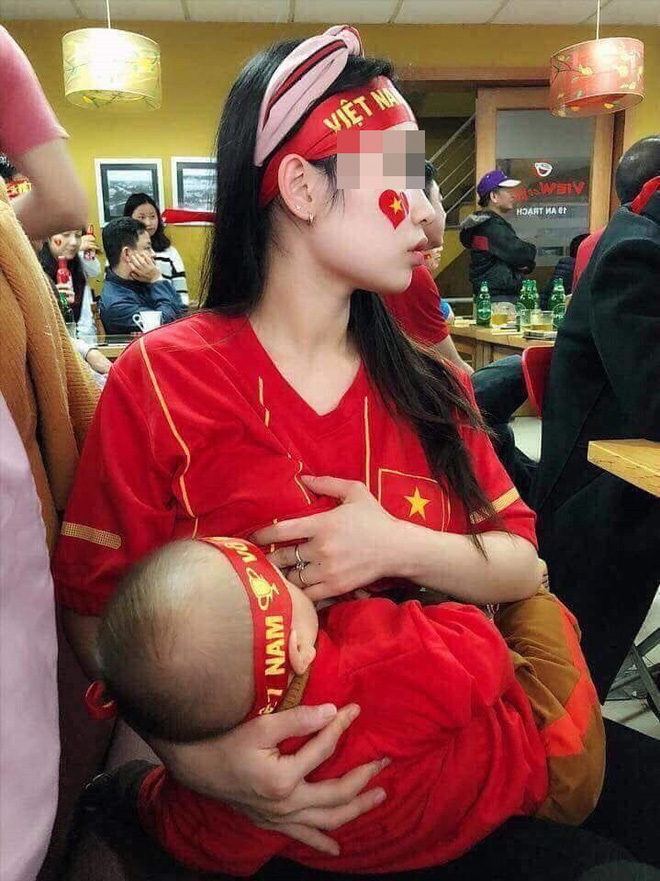 Mẹ vừa cổ vũ bóng đá vừa cho con bú.