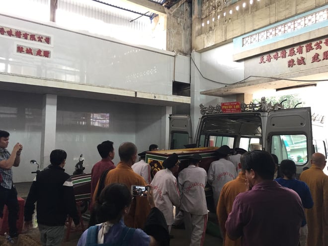 Người thân đưa thi hài bà Phượng ra xe để về chùa an táng