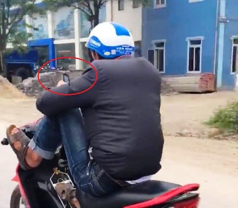 Hành động dùng chân điều khiển xe máy trong khi tay dùng điện thoại khiến thanh niên bị xử phạt hơn 7 triệu đồng (ảnh cắt từ clip)