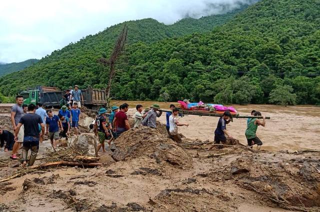 Thanh niên cáng người ra khỏi bùn lũ