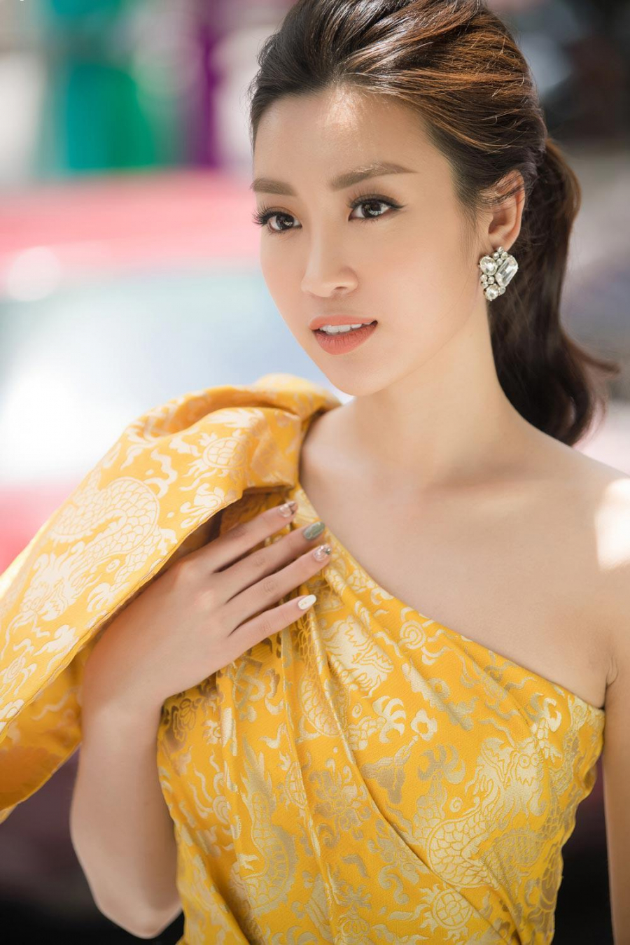 Nàng Hậu buộc tóc gọn và phụ kiện tối giản để khoe trọn bờ vai thon của mình. Chất liệu gấm cao cấp được nhập hoàn toàn từ nước ngoài, có độ óng ánh trên nền hoạ tiết rồng hoàng gia khiến mỹ nhân sinh năm 1996 thêm toả sáng. 