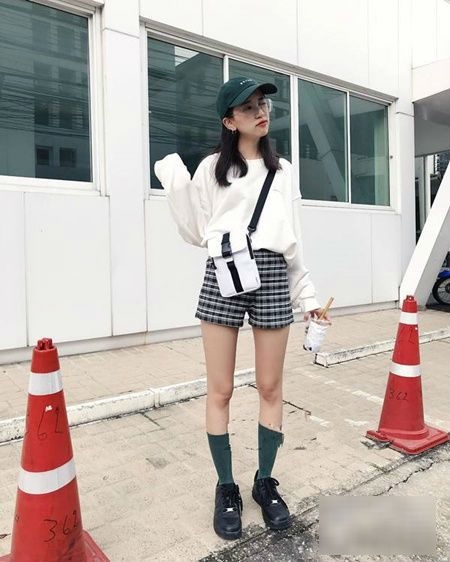 Áo dài tay kết hợp cùng quần short kẻ, túi đeo chéo đồng điệu đã mang đến set đồ mang đậm dấu ấn thanh lịch và hiện đại.    
