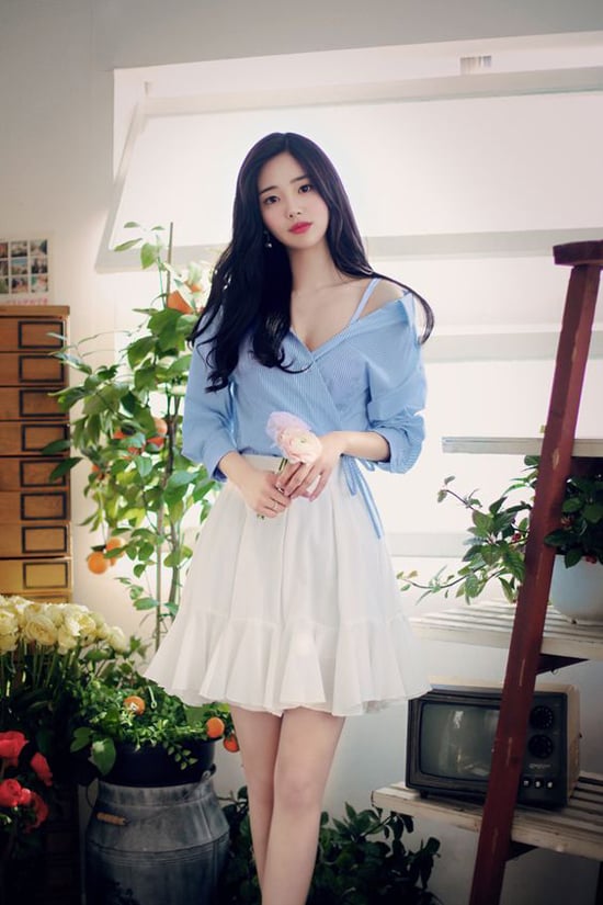 Sơ mi biến tấu kẻ trắng xanh hài hòa cùng chân váy chữ A được trang trí thêm bèo nhún to bản.    