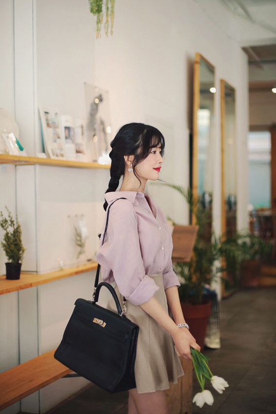 Sơ mi hồng tím lãng mạn được kết hợp cùng chân váy chữ A màu trung tính. Phong cách gợi cảm nhưng không kém phần thanh nhã cho các nàng công sở.    
