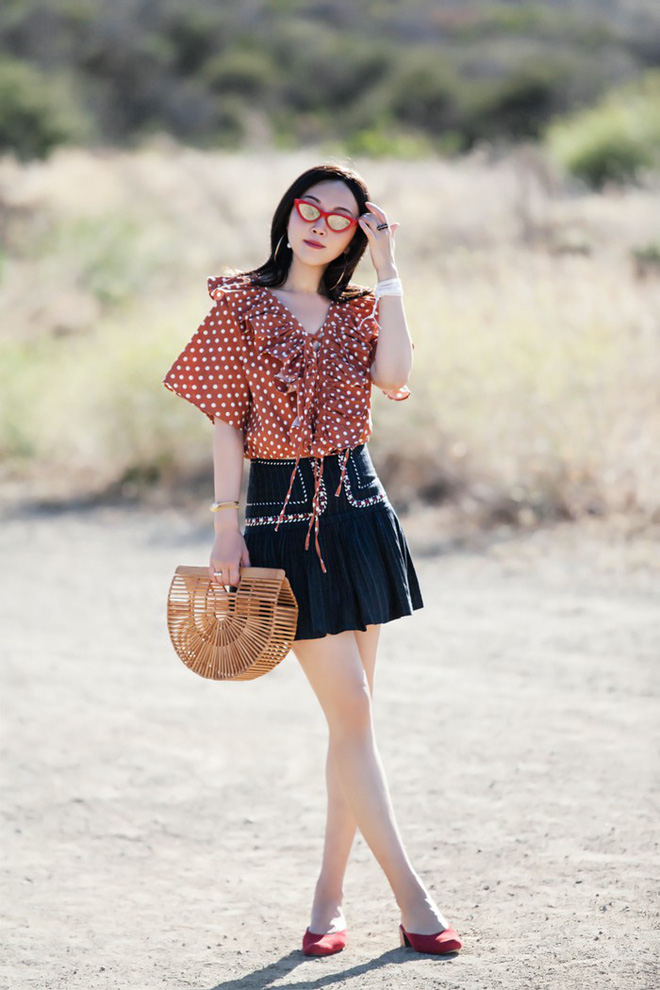 Chiếc áo blouse chấm bi được kết hợp đầy trẻ trung cùng chân váy ngắn xếp li, tinh tế hơn ở chỗ là cô nàng này chọn phụ kiện rất cùng tông với áo.    