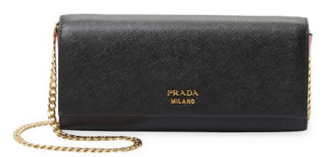 Meghan kết hợp bộ váy Prada với clutch cùng hãng, giá 1.280 bảng Anh (39 triệu đồng).    