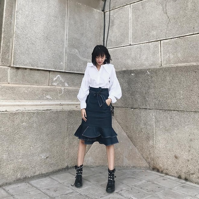 Phí Phương Anh mix sơmi tay phồng cùng chân váy ống loe và boots nạm đính độc đáo.  