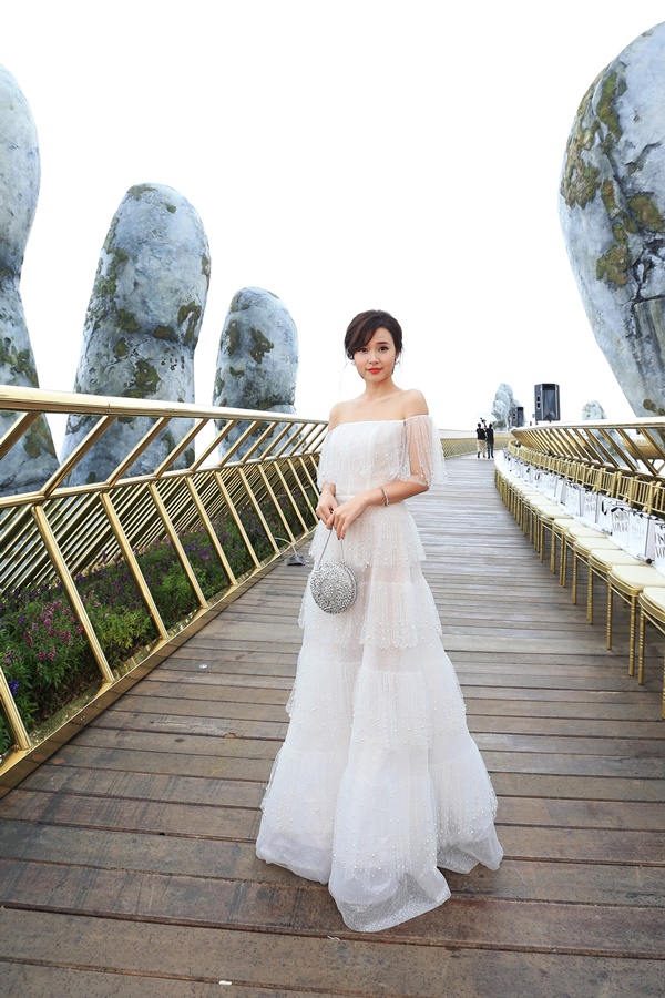 Midu rất may mắn khi có ảnh đẹp ngay trên cây cầu vàng khi trời không mưa. Cô nàng diện chiếc váy trắng ren khoe vai trần gợi cảm. Ở góc chụp này Midu sở hữu chiều cao không thua kém gì siêu mẫu    
