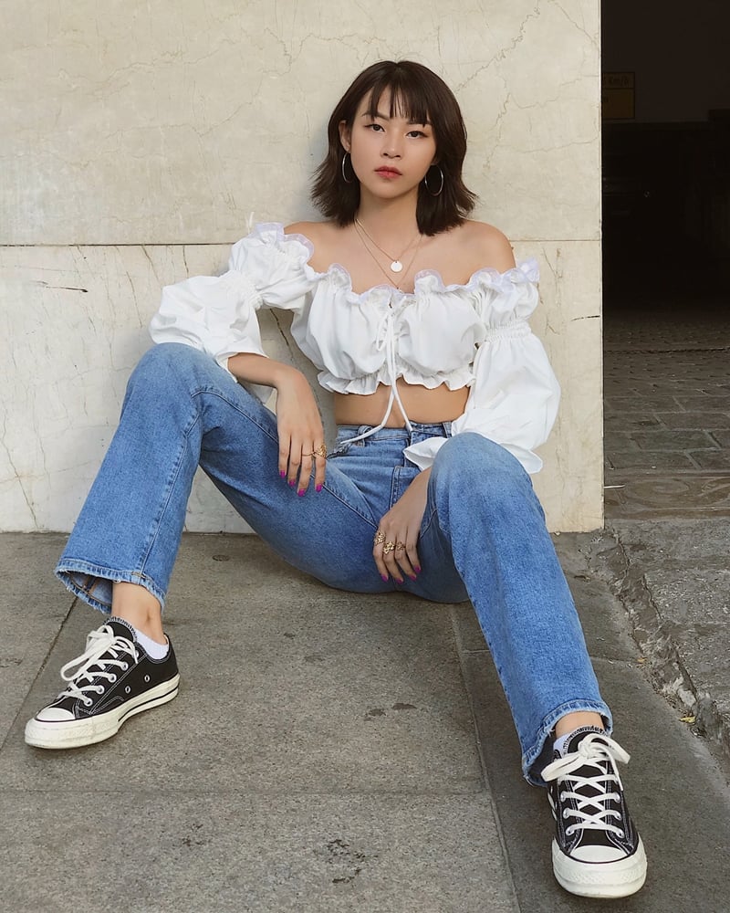 Phí Phương Anh ghi điểm tuyệt đối khi diện áo trễ vai tay phồng, diềm xếp bèo, để lộ vai trần và vòng eo không chút mỡ thừa. Quán quân The Face Việt Nam mùa 1 còn thể hiện cá tính phóng khoáng với quần denim cạp cao và giày thể thao.    
