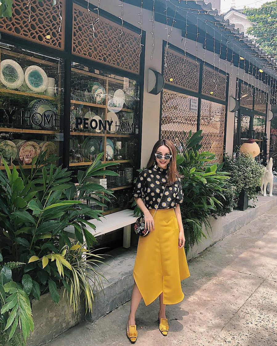 Cũng chọn phụ kiện xuyệt tông như Angela Phương Trinh, nhưng thay vì diện váy liền Yến Trang lại khéo kết hợp áo họa tiết hoa cùng chân váy vạt bất đối xứng. Cái khéo ở đây chính là ngay cả khi diện váy họa tiết thì Yến Trang cũng chú ý đến màu sắc sao cho hợp gu với váy.    