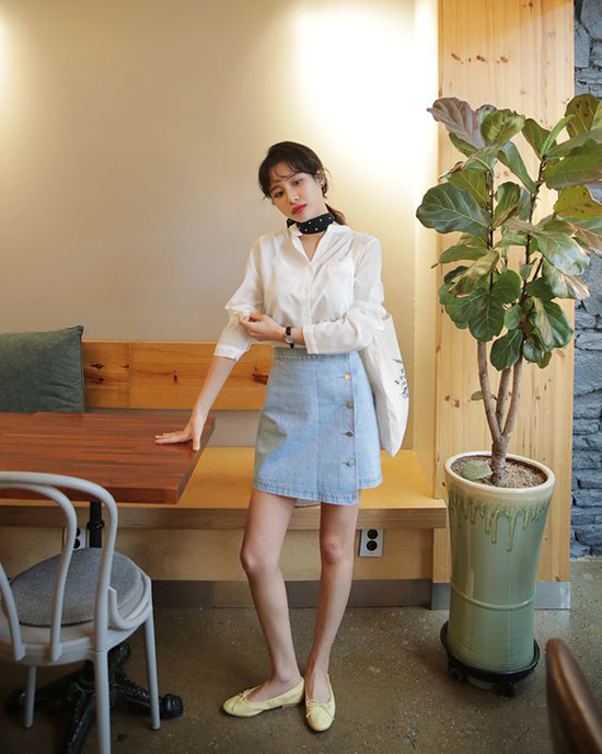 Đi cùng kiểu áo cài nút thông dụng là chân váy jeans vạt xéo, khăn turban, giày búp bê và túi tote.    