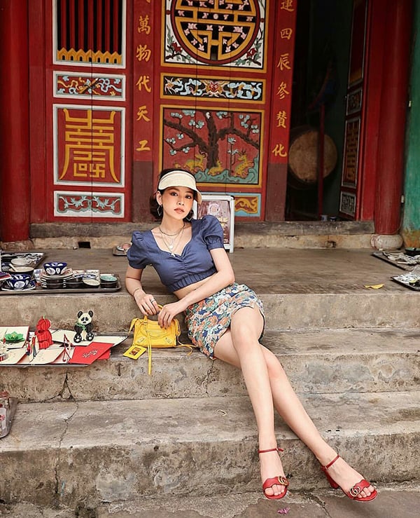 Áo hở eo được Chi Pu phối cùng chân váy ngắn, sandal Gucci và túi Balenciaga gam vàng nổi bật.    