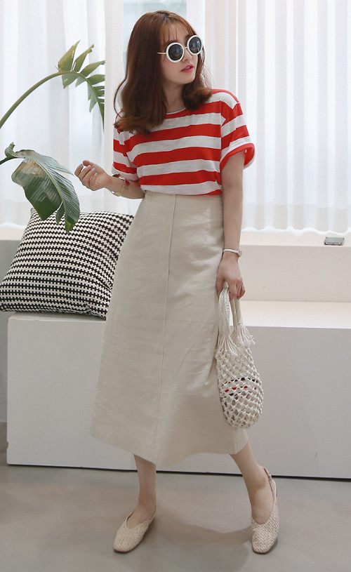 Áo thun kẻ sọc đỏ trắng trở thành điểm nhấn cho set đồ gồm chân váy midi, túi dây đan thủ công và giầy đế bệt.    